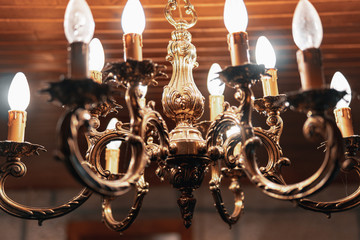  An old lamp with several lighted bulbs hanging from the ceiling