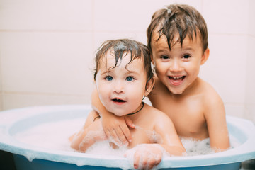 children, brother and sister in the bathroom swimming, playing splashing