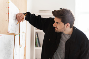 Fototapeta premium Poważny profesjonalny architekt człowiek w pracy biurowej z projektami na biurku.