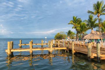 Tropical beach and pier with palm trees, resort and Marina in Florida Keys with Caribbean sea view.
