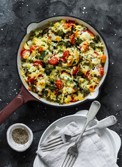 Vegetarian casserole ratatouille, baked in a frying pan on a dark background, top view