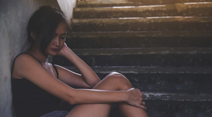 Sad depressed woman suffering from family life. Teenage girl sitting outside, on stairs feeling lonely. Young beautiful women thinking how to solve problem.