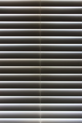 Closed bathroom blinds with sunlight behind