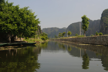 Fototapeta na wymiar Tour en un bote de remos llamado sampán por el rio Ngo Dong en Tam Coc, provincia de Ninh Binh, Vietnam