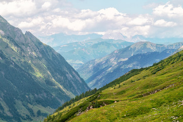 Fototapeta na wymiar Panorama of picturesque blue mountainsides and green alpine meadows, Austria