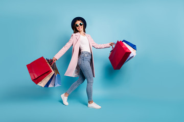 Full length photo of cheerful funky lady tourist in eyewear eyeglasses go shopping buy sales...
