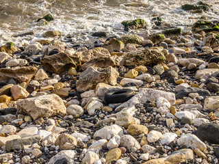 Abandoned car tyre on a rocky sesahore