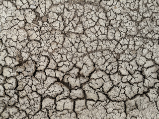 Dried cracked earth. Because of no rain and drought season.