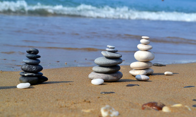 Three zen-style stonetowers on the sandy beach