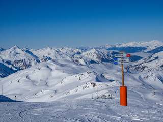 LES MENUIRES, FRANCE - February 2018: Directions pointer on a top of mountain in ski resort "3 valleys"