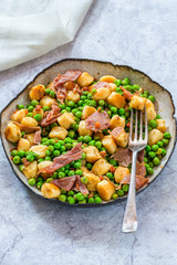 Potato gnocchi with green peas, pesto, proscuitto and chorizo in a bowl