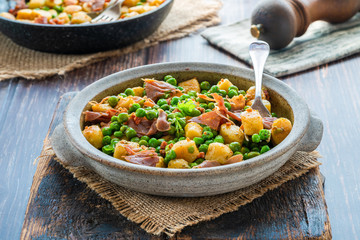 Potato gnocchi with green peas, pesto, proscuitto and chorizo in a bowl
