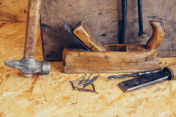 Old construction tools on a wooden workbench flat lay background. Carpenter table. Woodwork