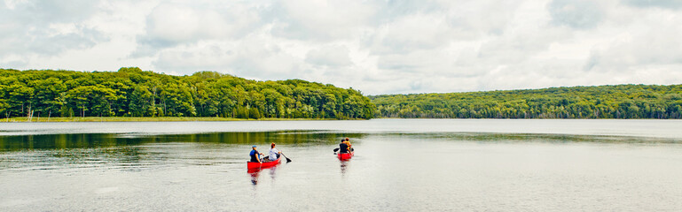 Canada forest park nature with family friends riding in red kayaks canoe boats in water. Beautiful...