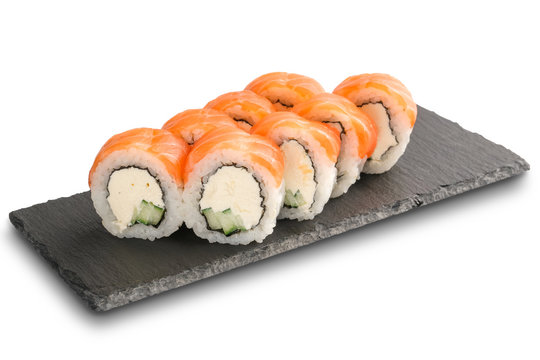 Sushi Rolls with salmon, cucumber, nori leaf and Cream Cheese inside on black slate or stone shale surface isolated
