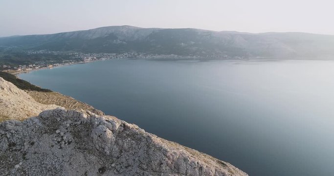 Aerial Drone flight in summer over mountains on the island krk near baska in croatia during sunrise over the sea