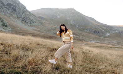 Naklejka premium woman standing with hands up achieving the top. Girl welcomes a sun. Conceptual design. Successful woman hiker open arms on sunrise mountain top. Girl in long white dress in the mountains.