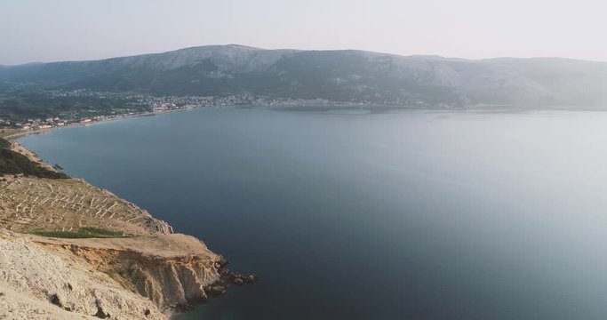 Aerial Drone flight in summer over mountains on the island krk near baska in croatia during sunrise over the sea