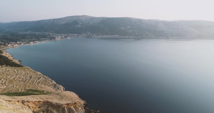 Aerial Drone flight in summer over mountains on the island krk near baska in croatia during sunrise over the sea