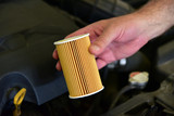 Repairman holding an new car oil filter