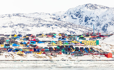 Arctic city center panorama with colorful Inuit houses on the rocky hills covered in snow with snow and mountain in the background, Ilulissat, Avannaata municipality, Greenland © vadim.nefedov