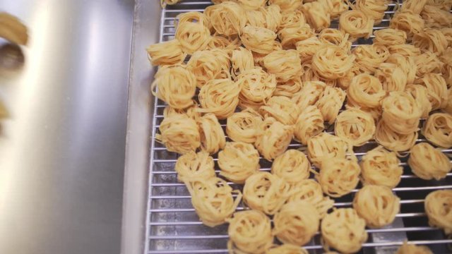 Overhead Shot Of Italian Pasta Tagliatelle Nests Passing On A Conveyor Belt In A Pasta Factory.