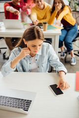 schoolchildren laughing while bullying sad girl on foreground