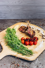 Meat ribs with vegetables on a wooden Board with herbs.