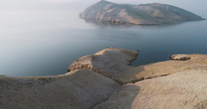 Aerial Drone flight in summer over mountains on the island krk near baska in croatia during sunrise over the sea