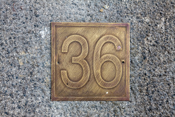 Number 36, thirty six, street number sign on the wall