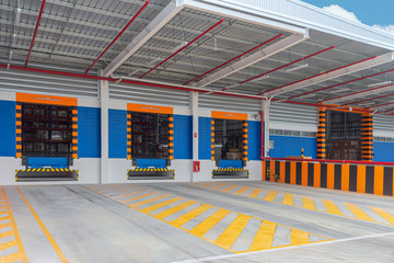 Gates entrance ramps of distribution warehouse with docking station for trucks loading goods.