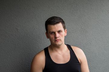 The young guy. Irritation, anger and fatigue. Grey background.