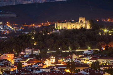 Pombal castle in Portugal, seen from the viewpoint at dusk, with part of the city of Pombal at the base of the hill.