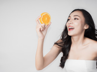 portrait asian beautiful woman.Closeup beauty skin  and hand holding fresh orange.isolated white background copy space.