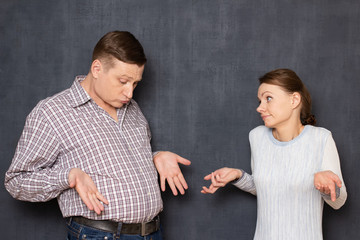 Couple is being indignant of man's big stomach appearing