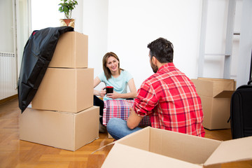 The young couple move into a new apartment, sit on the floor