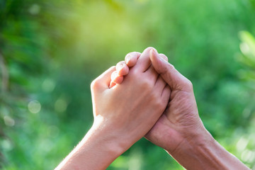 Closeup hands of people shaking up about winner on nature background.