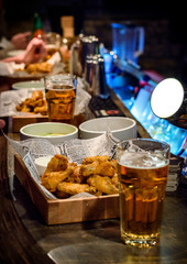 Fried spicy chicken wings and beer on the bar counter