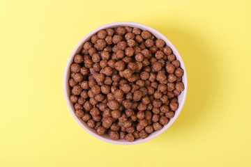 dry breakfast in a plate on a colored background top view. cereal