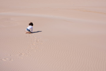 Young boy playing alone in sand
