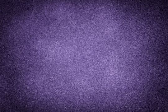 Dark violet matte background of suede fabric, closeup.