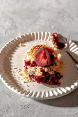 fresh made plum crumble on white plate