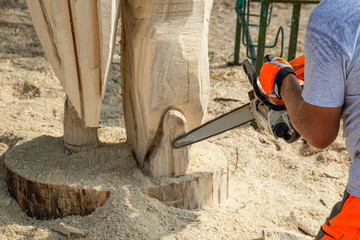 Chainsaw work on wood. Wood carving sculptures. Sawing firewood.