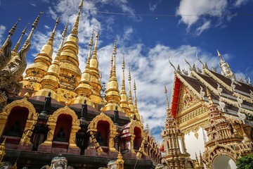 Grand golden pagoda on cloudy day, northern thailland known as Lanna style.