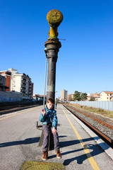 Young tourist boy with the camera on railway station