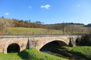 tuscany landscape with old stone bridge over the river