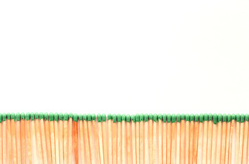  row of matches with green heads on a white background