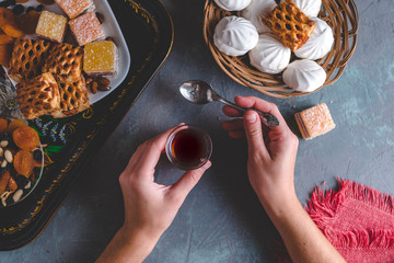 Turkish tea in traditional glass with sweets, dried fruits and nuts for a teatime. Top view