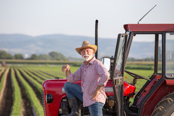 Famer standing beside tractor © Budimir Jevtic