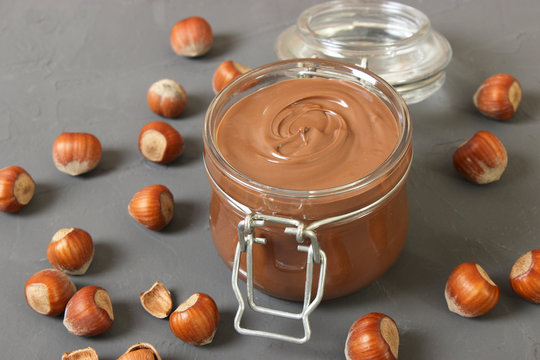 chocolate paste in a glass jar on a colored background. Chocolate butter, chocolate sauce.